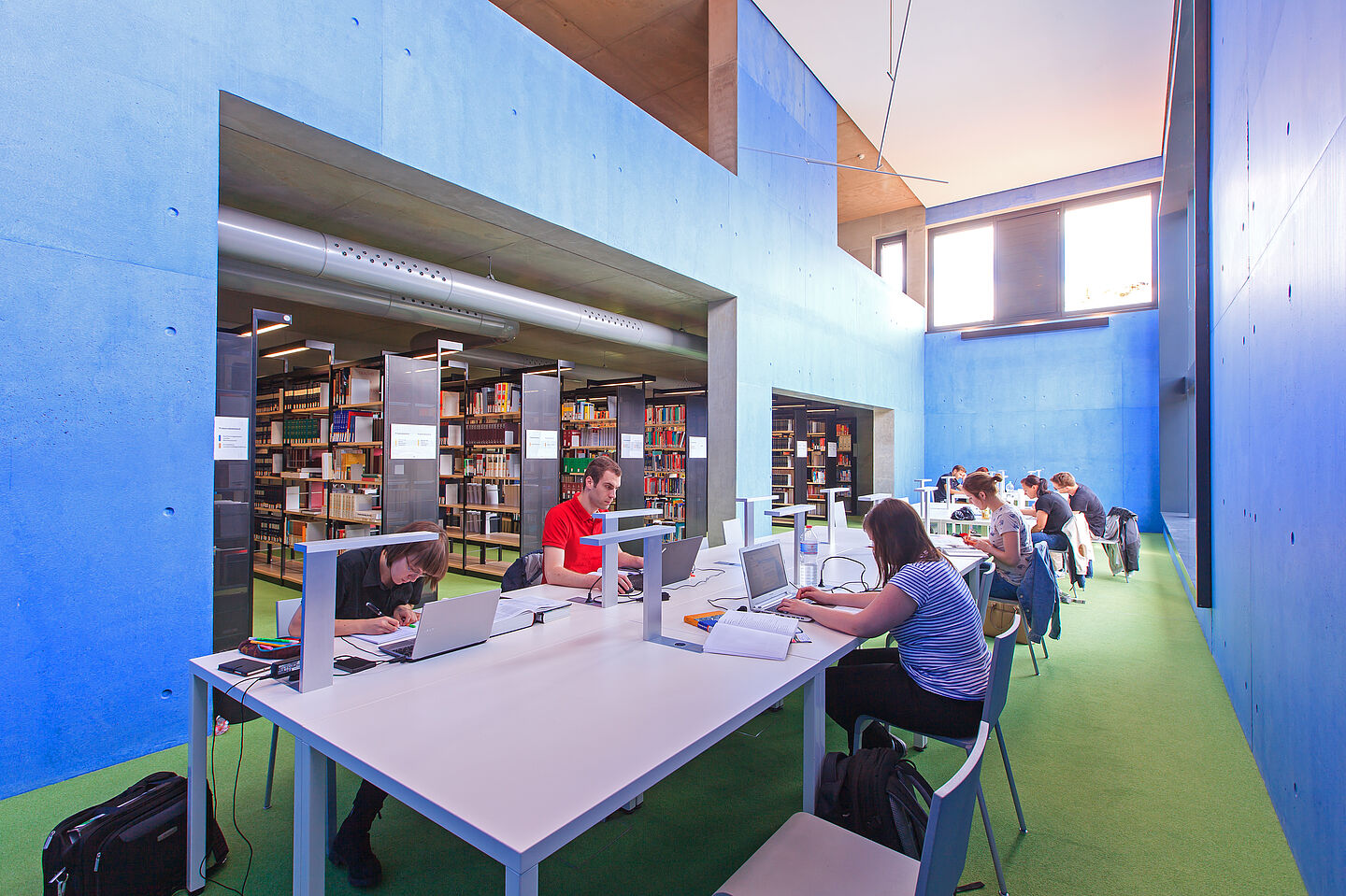 Blick in die HTWK-Hochschulbibliothek. (Foto: Swen Reichhold/HTWK Leipzig) Menschen arbeiten in einer Bibliothek und sitzen am Tisch