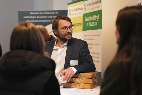 Prof. Dr. Björn Höhlig ein Mann unterhält sich an einem Messestand