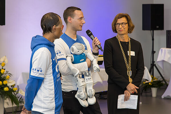 Sascha Hassler, Hannes Hinerasky vom Nao-Team HTWK und HTWK-Rektorin Prof. Gesine Grande (v.l.) im Gespräch - und ein Nao darf natürlich nicht fehlen. (Foto: H. Gerischer)