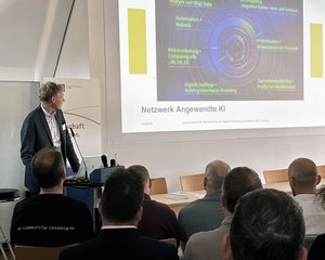 Netzwerk Angewandte KI Ein Mann hält einen Vortrag und schaut zur Präsentation