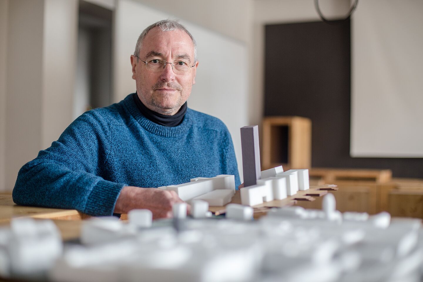 Mann mit Architekturmodellen.