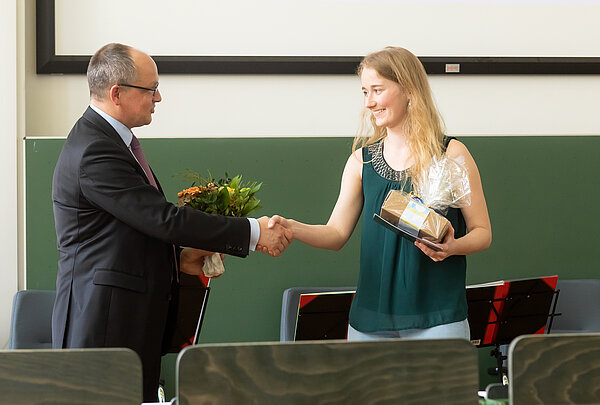 HTWK-Rektor Prof. Mark Mietzner beglückwünscht Preisträgerin Sophie Schulze. (Foto: Swen Reichhold/HTWK Leipzig) Mann gratuliert Frau in Hörsaal