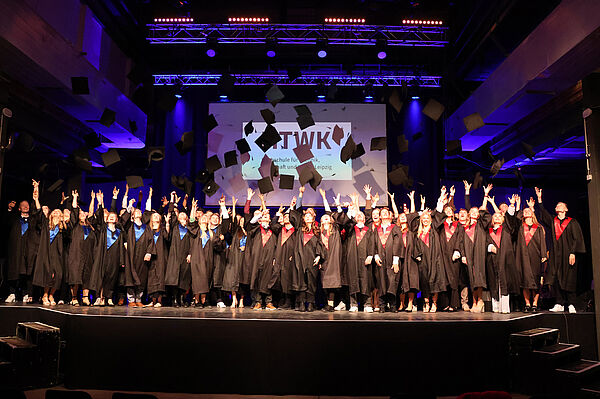 Die Alumni werfen ihren Hut in die Luft.