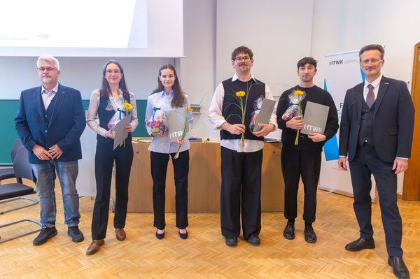 v. l. n. r.: Prof. Lutz Engisch, Josepha Eliane Kahnt, Isabell Schäker, Leo Dinkelacker, Alexander Ostrovskis, Prof. Jean-Alexander Müller Gruppe von Studierenden mit Urkunden und zwei Professoren steht in einem Hörsaal