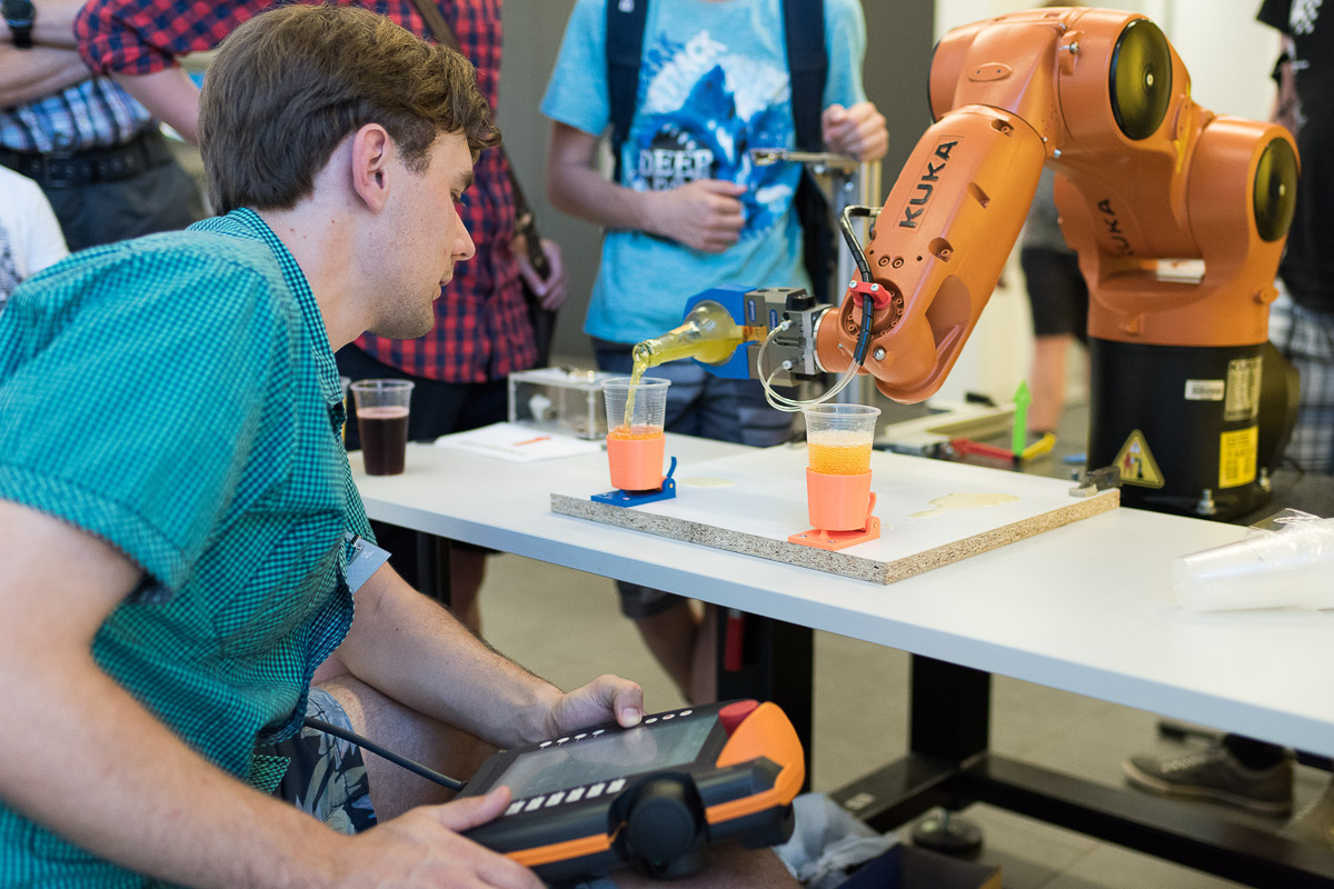 Lange Nacht der Wissenschaften (Foto: Johannes Ernst) Ein Industrieroboter schenkt Limo ein.