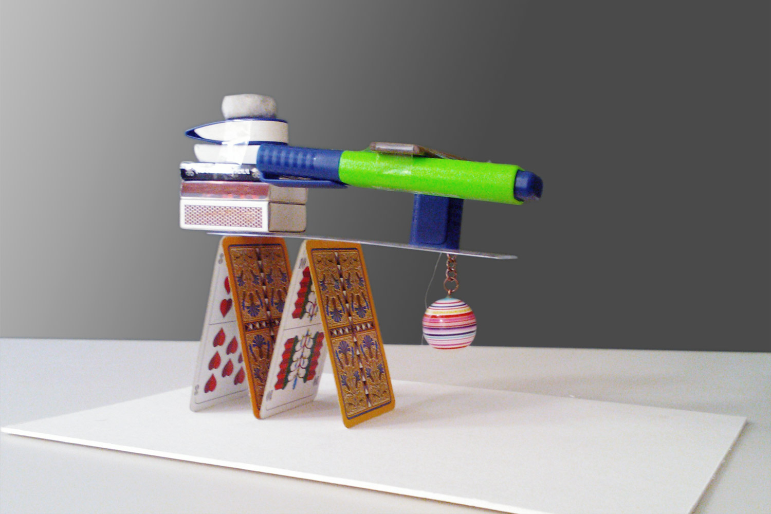 Modell einer Tragwerkskonstruktion aus Spielkarten, Streichholzschachteln, Kugelschreiber und  Radiergummis.